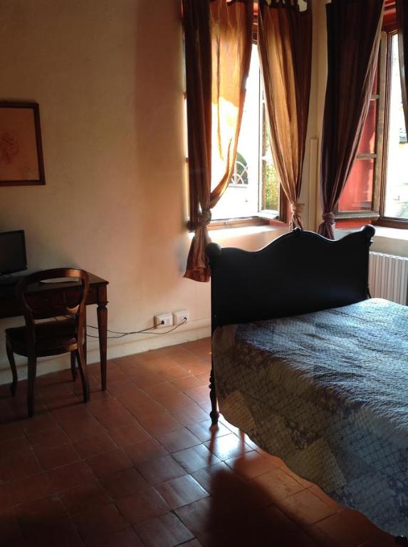 a bedroom with a bed and a table and window at Room and Breakfast Torre in Felino