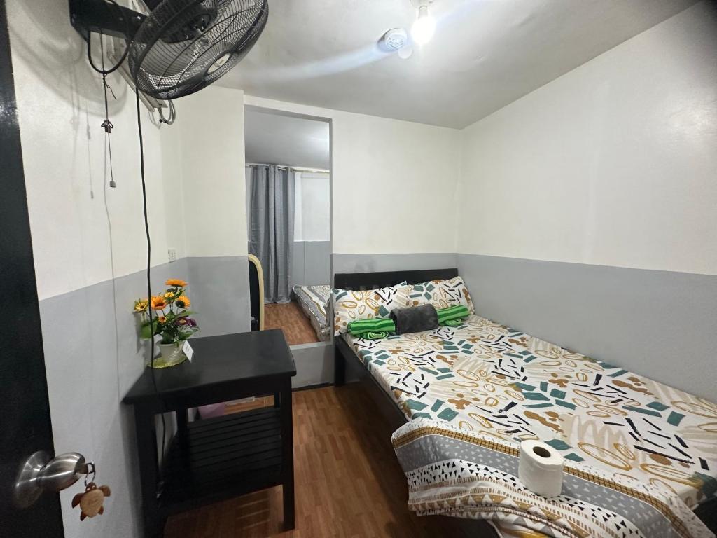 a small bedroom with a bed and a table at Maui's Place in Badian