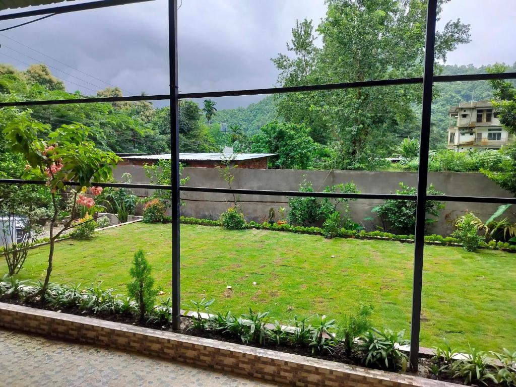 a view of a garden from a window at Renu's Hillside Homestay in Kamakhya