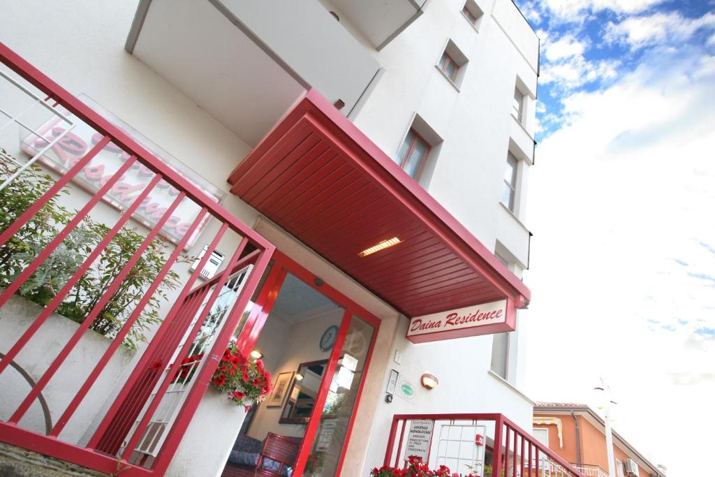una tienda frente a un edificio con una puerta roja en Daina Residence, en Lido di Jesolo