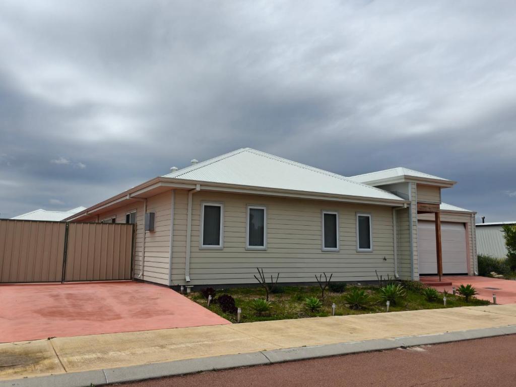 ein Haus in einer Straße mit einem Zaun in der Unterkunft Jurien Bay WA, 4-bedroom home in Jurien Bay