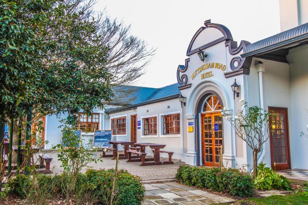 a building with a picnic table in the courtyard at The Nottingham Road Hotel in Nottingham Road