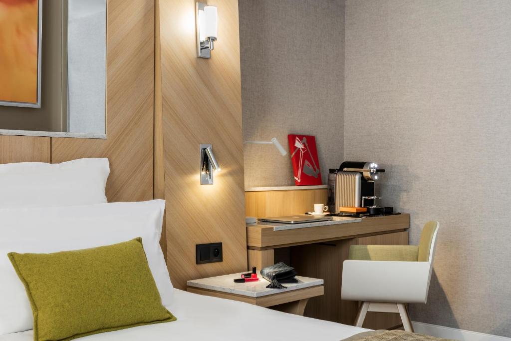 a hotel room with a bed and a desk at Hotel Louvre Saint-Honoré in Paris