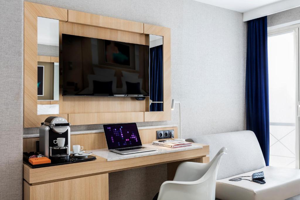 a room with a desk with a laptop on it at Hotel Louvre Saint-Honoré in Paris