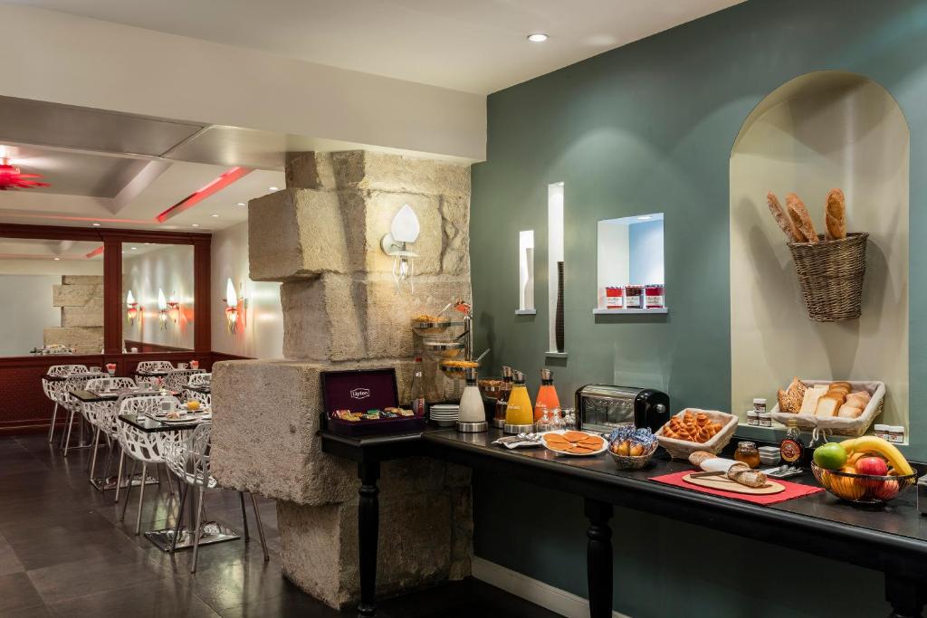 a restaurant with a buffet of food on a counter at Hotel Louvre Saint-Honoré in Paris