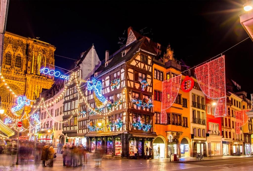 a building with christmas lights on a city street at Camping ClicoChic Au Clair Ruisseau in Gerstheim