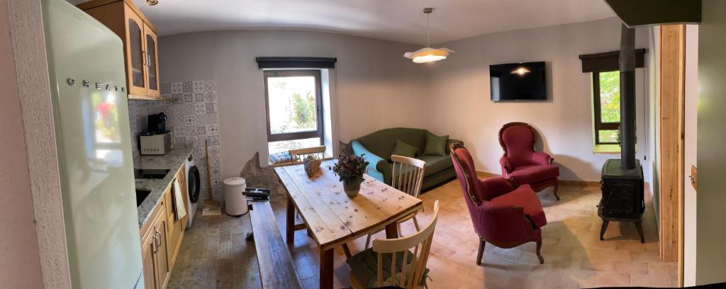 a kitchen with a table and chairs and a living room at Entrenogueras in Huerta del Marquesado