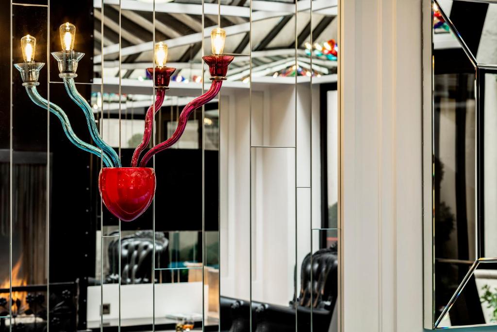 a red glass vase with candles in a window at Hotel Louvre Saint-Honoré in Paris