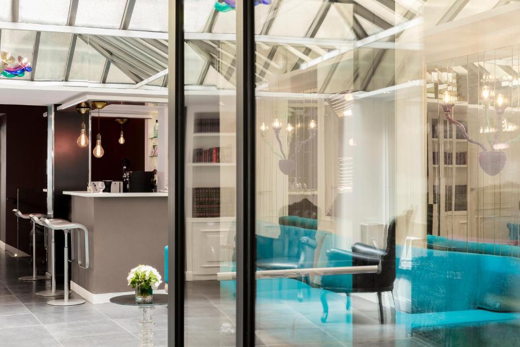 a salon with blue chairs in a room at Hotel Louvre Saint-Honoré in Paris