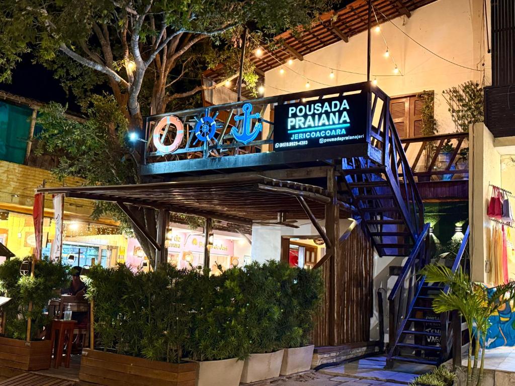 a building with a sign for a restaurant at Pousada Praiana Jericoacora in Jericoacoara