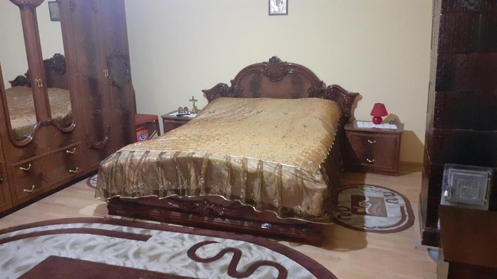 een slaapkamer met een bed met een houten hoofdeinde bij Alex Lux apartment in Glimboca