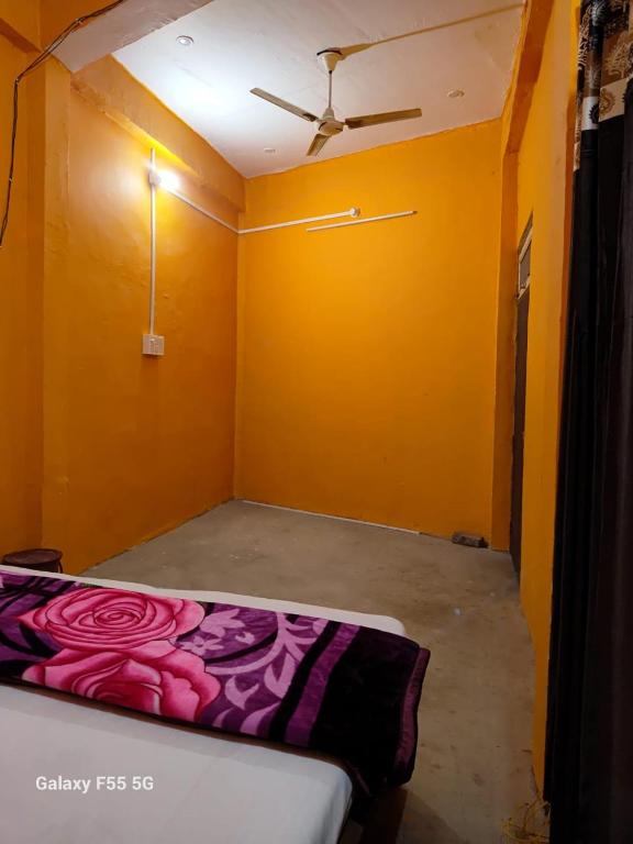 a room with a bed in a room with yellow walls at DIOMAND HOTEL AND RESTURENt in Bilgrām