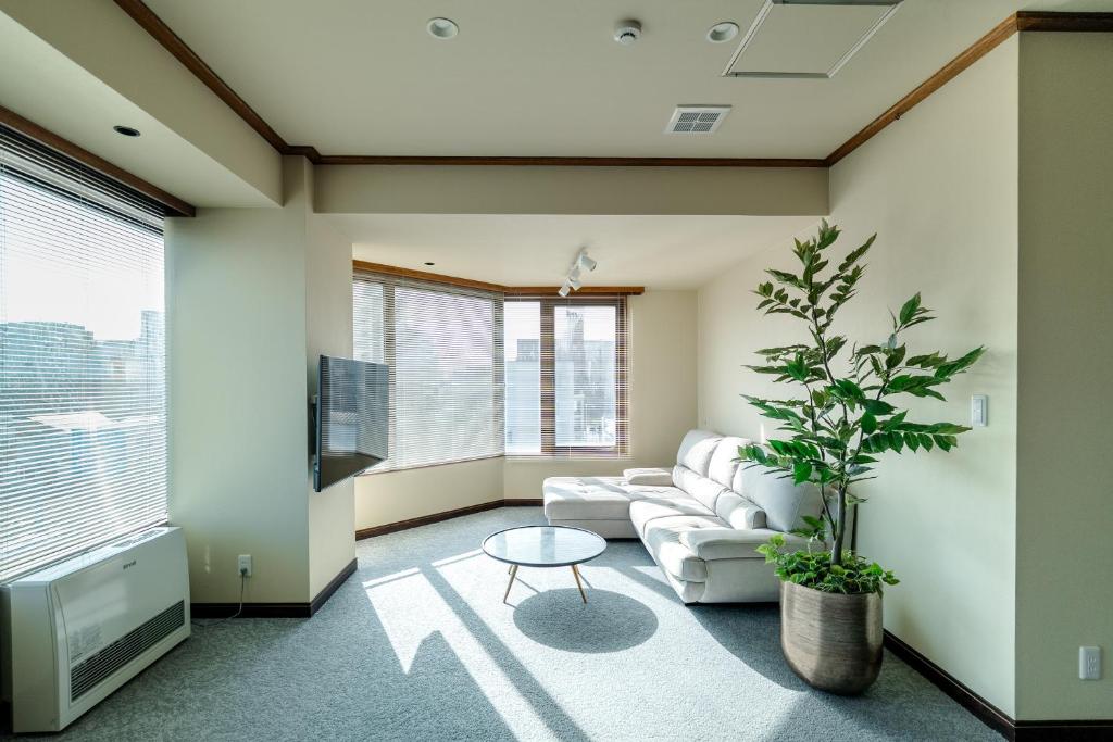 sala de estar con sofá y maceta en Cise kawakami2, en Kushiro