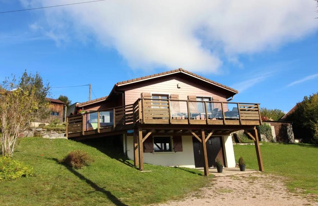 a house on a hill with a deck at Chalet de Grany, magnifique vue sur le lac de Gérardmer in Gérardmer