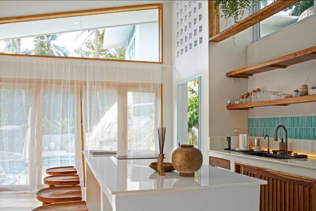 a kitchen with white counters and a large window at Villa Verde Ko Phangan in Haad Pleayleam
