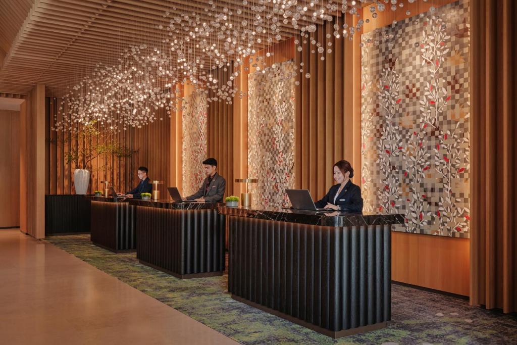 Multiple reception desks beneath a striking canopy of suspended lights.