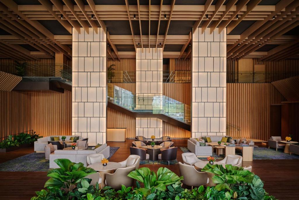A formal lobby lounge framed by tall illuminated columns and indoor planting.