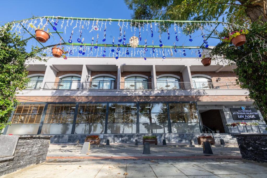 Tek Hotel Mürefte في Şarköy: مبنى به مجموعة من الأضواء الزرقاء أمامه