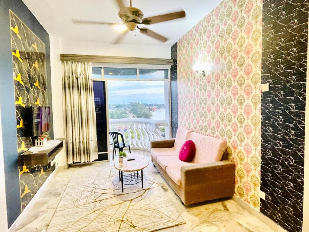 a living room with a couch and a table at GloryBeachResort2BedroomWifiNetflixFreeparking in Port Dickson