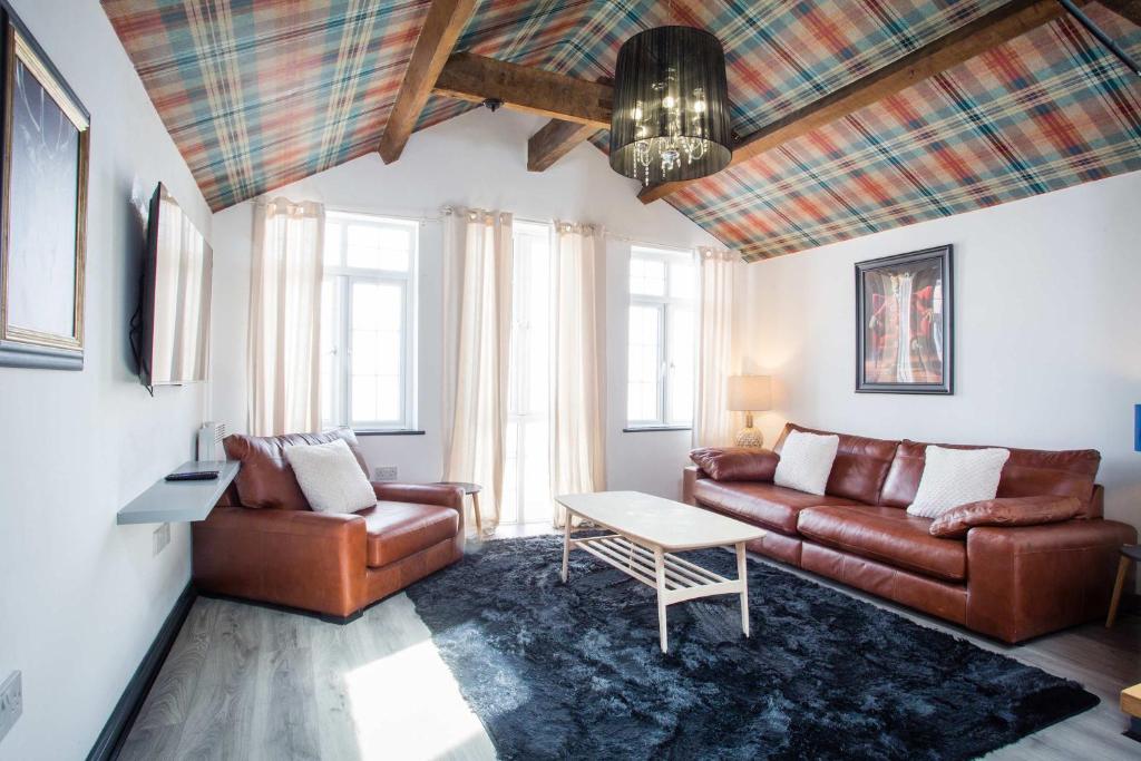 a living room with a couch and a table at The Coach House by The Hive WA1 in Warrington