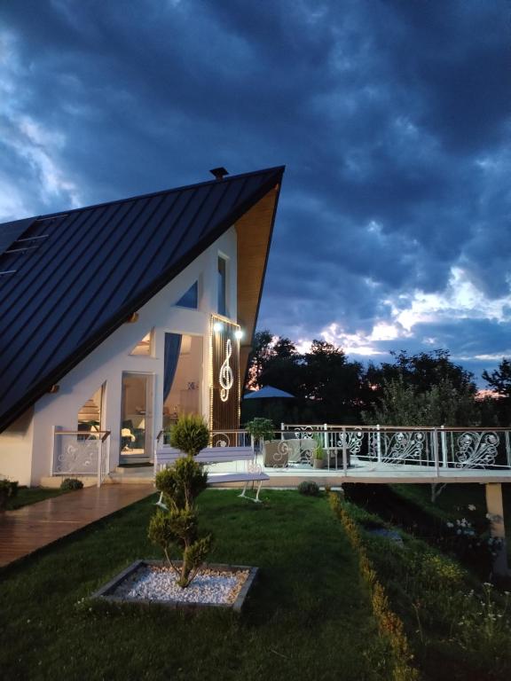 a house with a black roof and a bridge at Villa Stradivaryus in Sighetu Marmaţiei