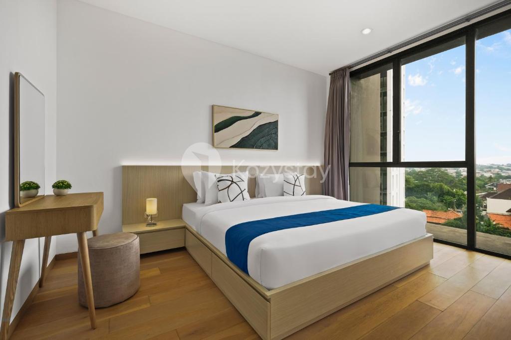 a bedroom with a large bed and a large window at Oswin by Kozystay - Cilandak in Jakarta