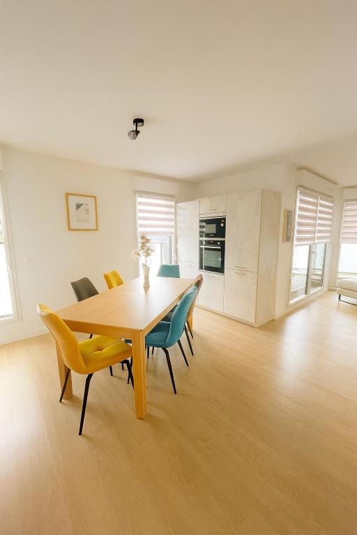 a dining room with a wooden table and chairs at Balcon sur docks - 4 lits - 4 beds in Le Havre