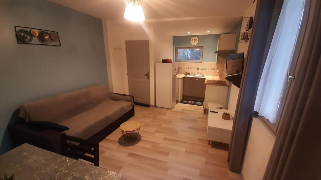 a small living room with a couch and a kitchen at 2-bed apartment in Limoges