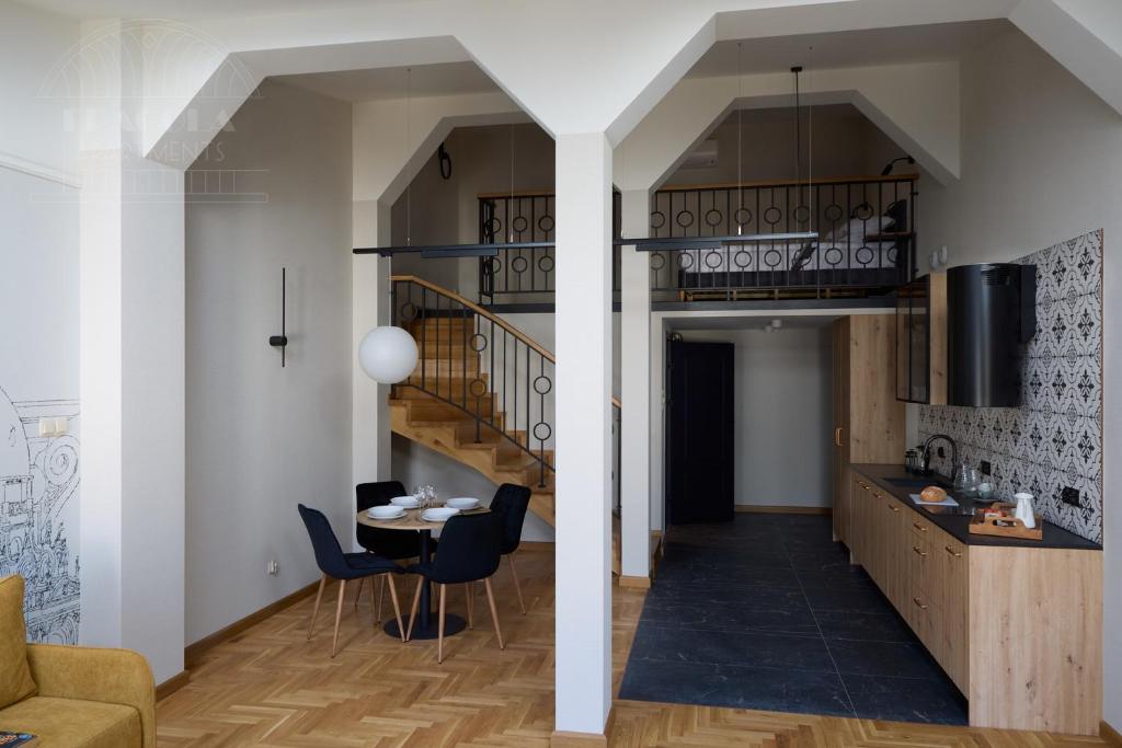 a living room with a staircase and a table and chairs at Art Palace - Fragola Apartments in Kraków