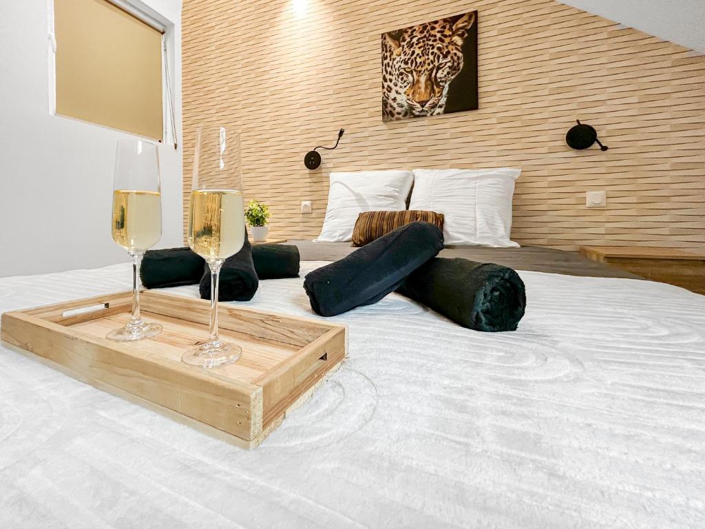 a large white bed with two wine glasses on it at Fibre Ultra-Rapide, Lit Queen Size, Cosy & Calme in Tourcoing