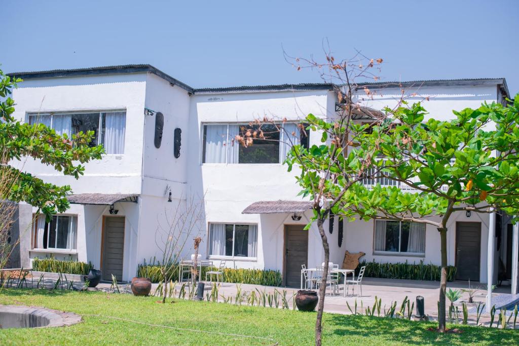 a white building with tables and chairs in a yard at Blue Waters by Serendib in Senga