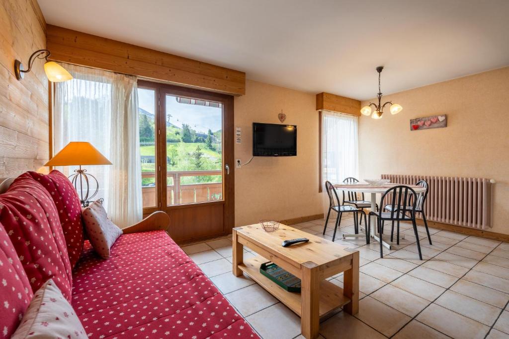 un salon avec un canapé et une table dans l'établissement Deux Vallées 2, à La Clusaz