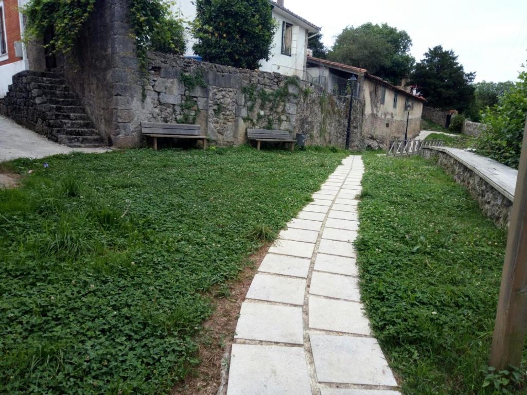 La Cavada的住宿－Pension Dehesa，两长椅庭院中的石头路
