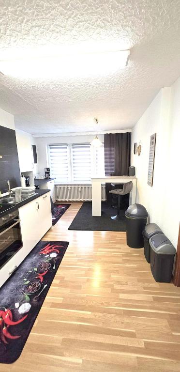 a living room with a kitchen with a table and a desk at Ferienwohnung FeLu in Wadgassen