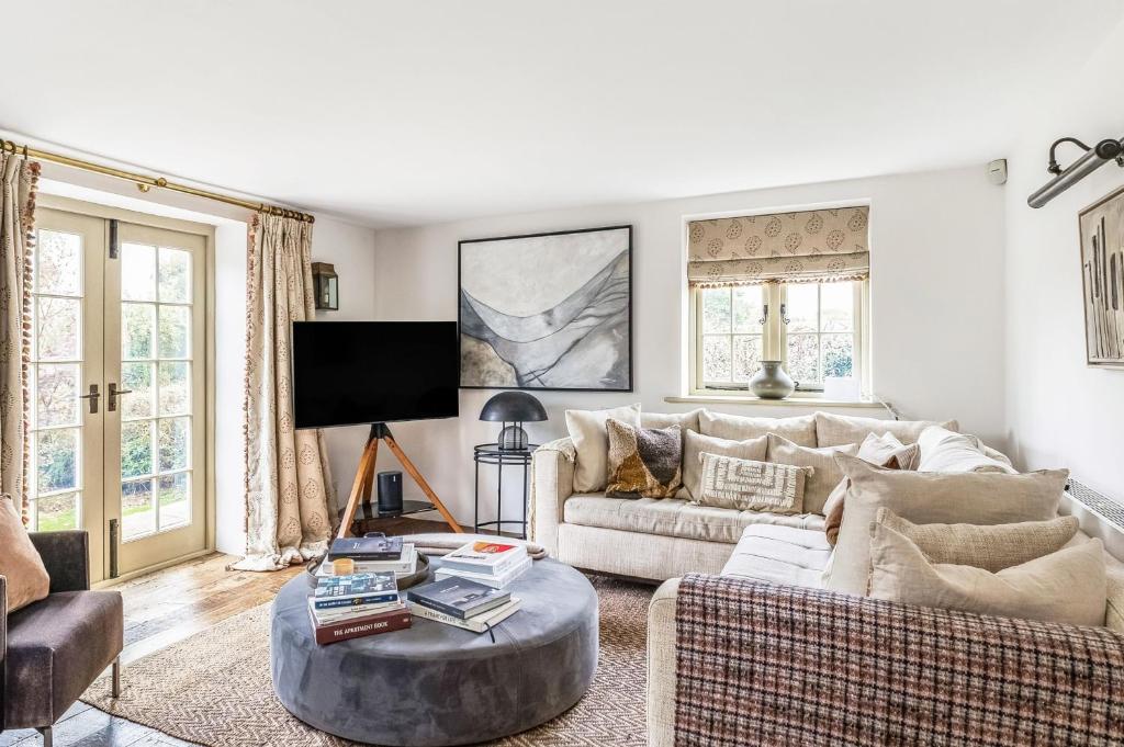 ein Wohnzimmer mit Sofa und Tisch in der Unterkunft Pelsham Farm Cottage in Peasmarsh