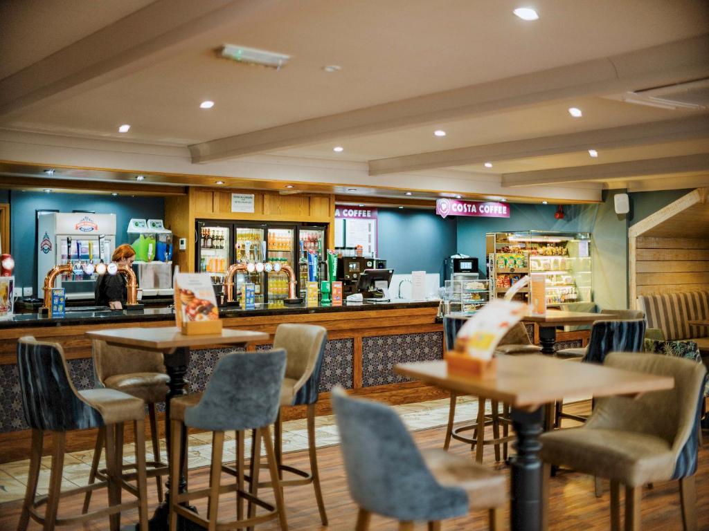 a restaurant with tables and chairs and a counter at Coastfields Holiday Village in Ingoldmells