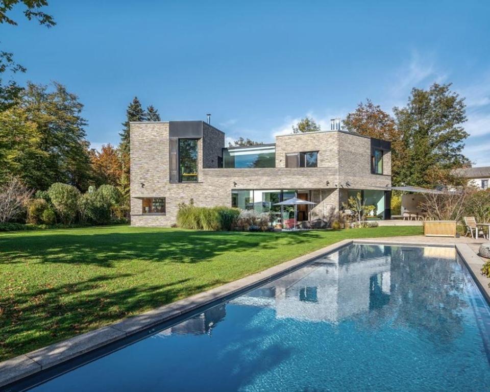 una casa con una piscina di fronte di Villa Kubic with Pool a Friedrichshafen