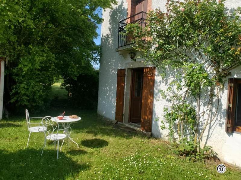 un tavolo e sedie nel cortile di una casa di Le Lion de Venise a Saulon-la-Rue