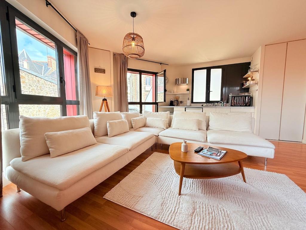 een woonkamer met een witte bank en een tafel bij Le Rubis - hyper centre et proche plage in Dinard