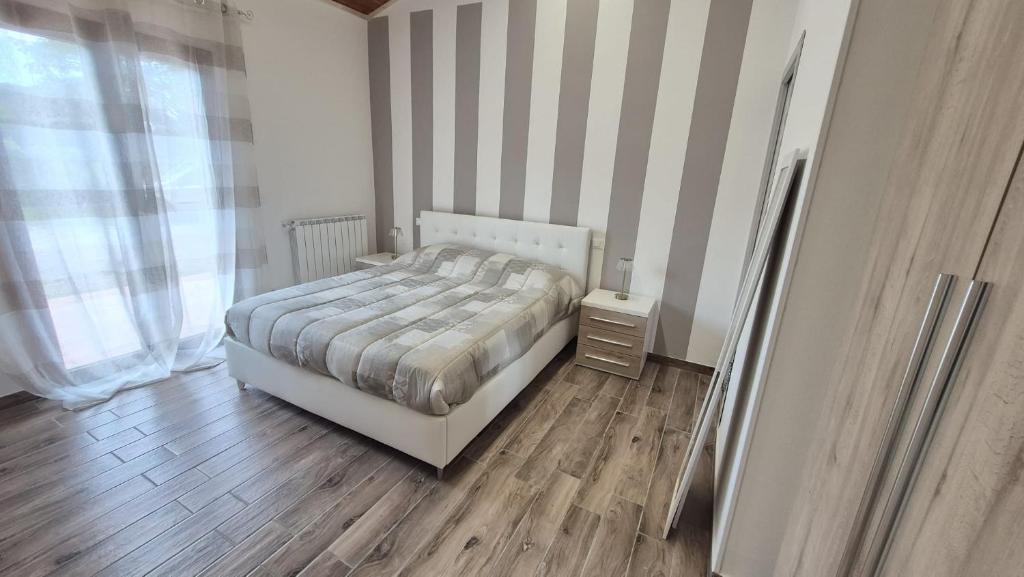 a bedroom with a bed and a striped wall at Il Casolare - Oasi verde Relax tra le colline Toscane in San Giovanni Valdarno