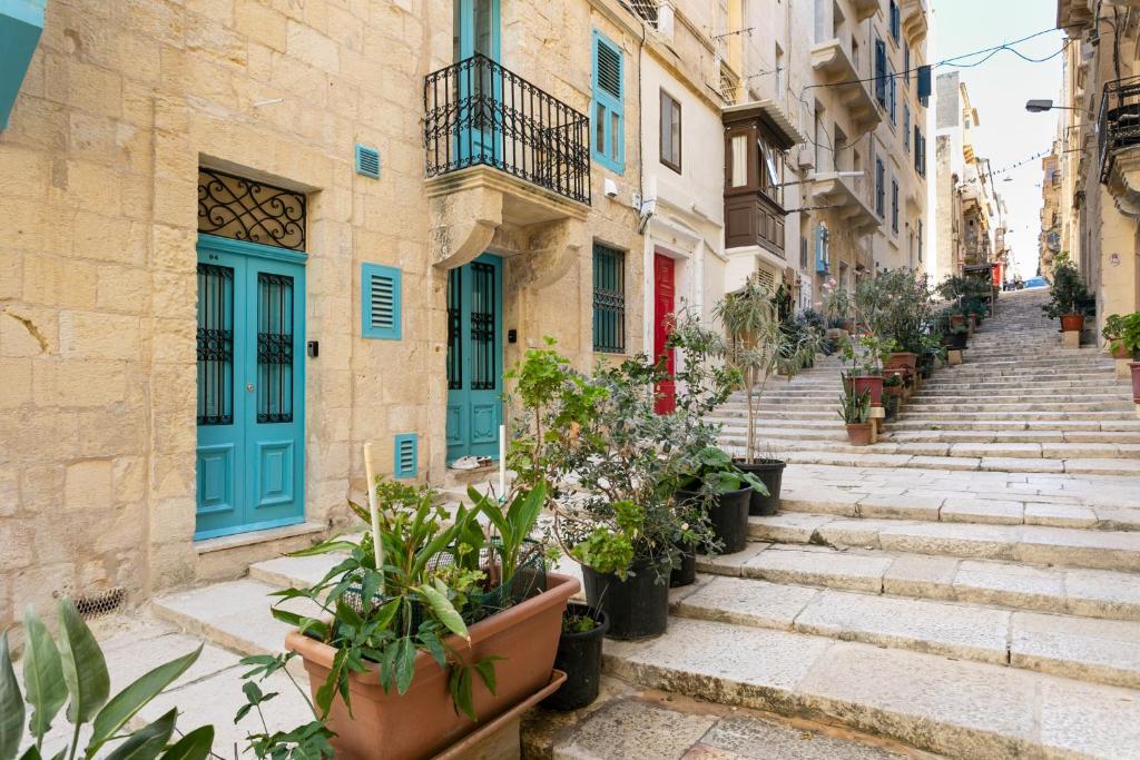 an alley in an old town with potted plants at Valletta Letcom Studio in Valletta