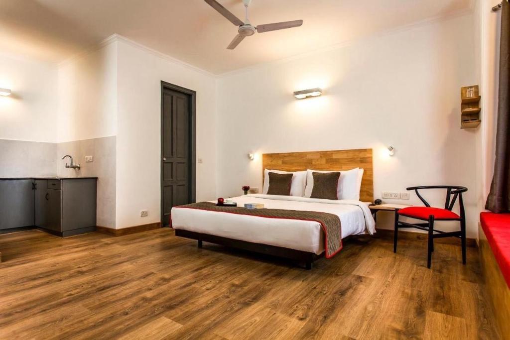 a bedroom with a large bed and a red couch at Townhouse Golkonda Fort Formerly Hotel Langar Houz in Haidar Sāhibgūda