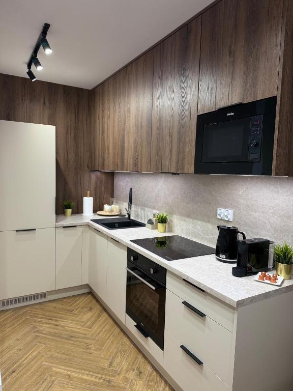 Una cocina con gabinetes blancos y un horno de estufa. en Apartament OMEGA, en Nysa