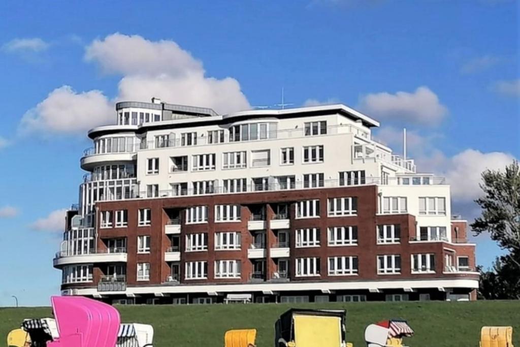 a large white building with chairs in front of it at Se 06 Haus Seeterrassen in Cuxhaven