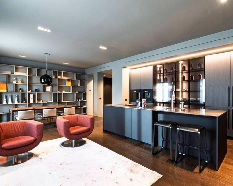 a kitchen with a bar with red chairs and a counter at Karl Penthouse in Rostock