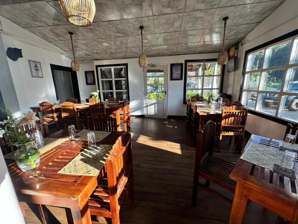a restaurant with wooden tables and chairs and windows at CRAB and STAY in Nuwara Eliya