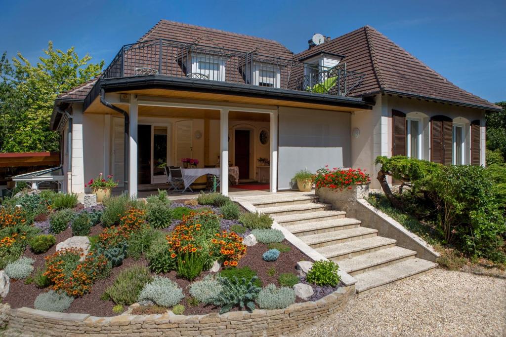 une petite maison avec un jardin en face de celle-ci dans l'établissement Nuits et Jardin, à Nuits-Saint-Georges