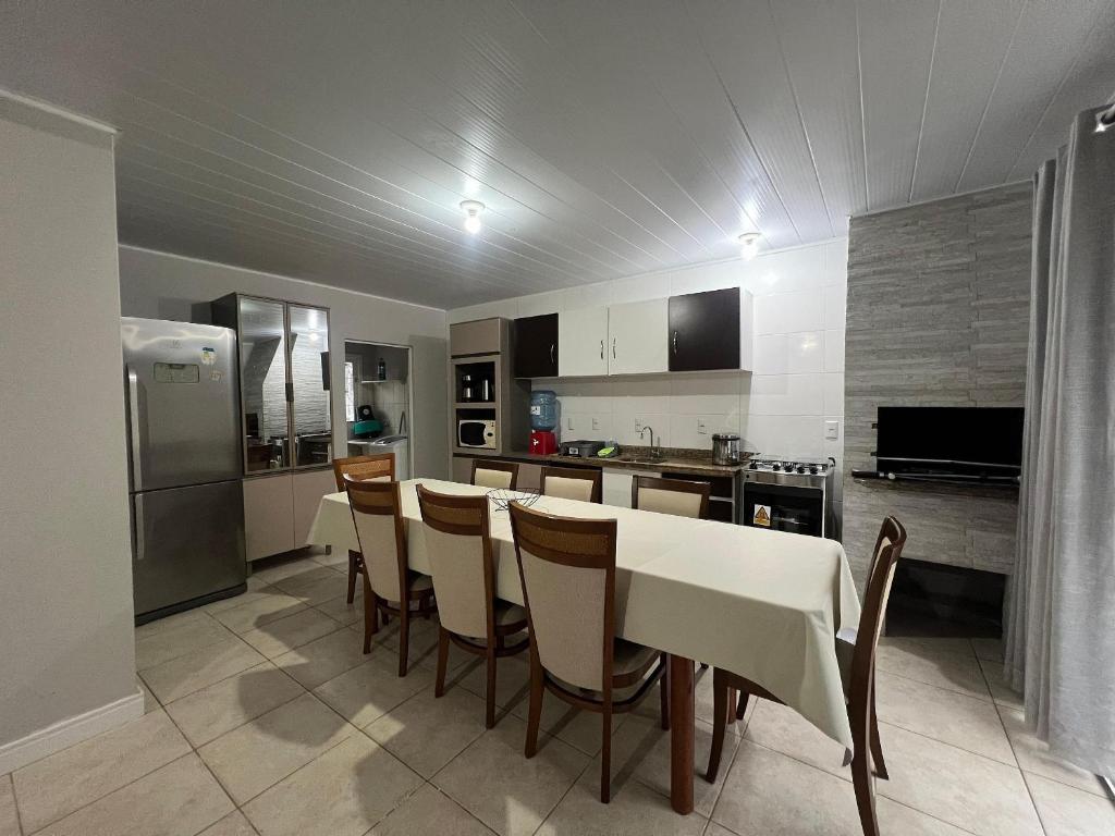 a kitchen with a table and chairs in a kitchen at Casa de 03 dormitórios no centro de Bombinhas in Bombinhas