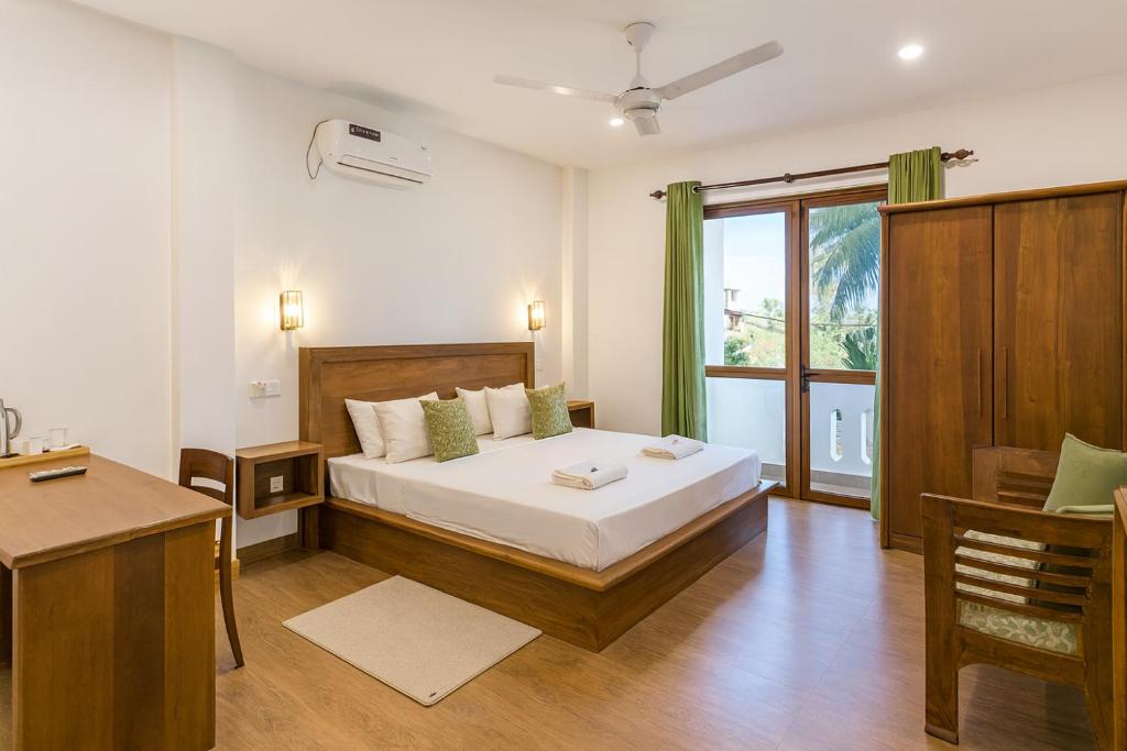 una camera da letto con un letto grande e una finestra di Kuvin Villa a Hikkaduwa