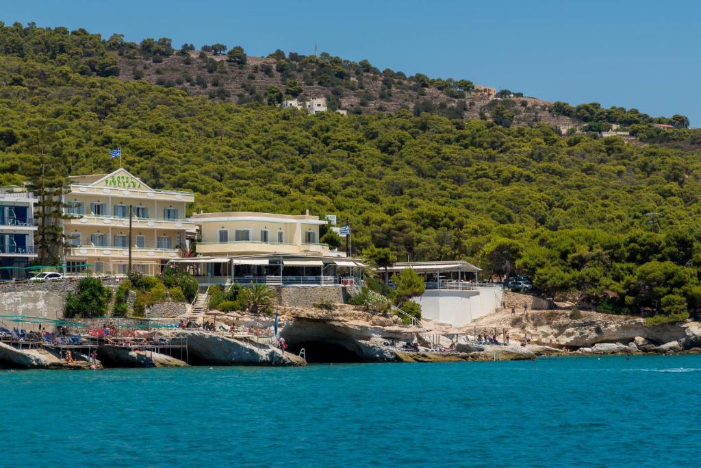 een groot huis op een heuvel naast het water bij Panorama Hotel in Agia Marina Aegina